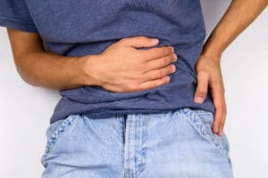 Young man holding abdomen in pain, hernia pain